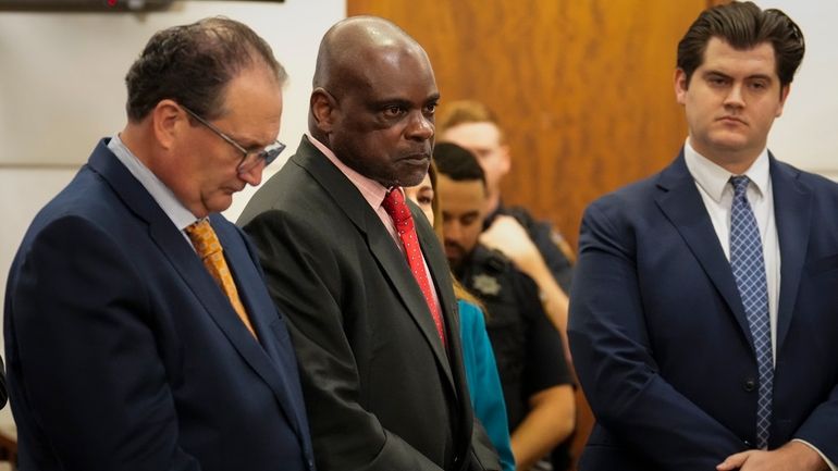 Retired Houston Police Department officer Gerald Goines, center, listens to...