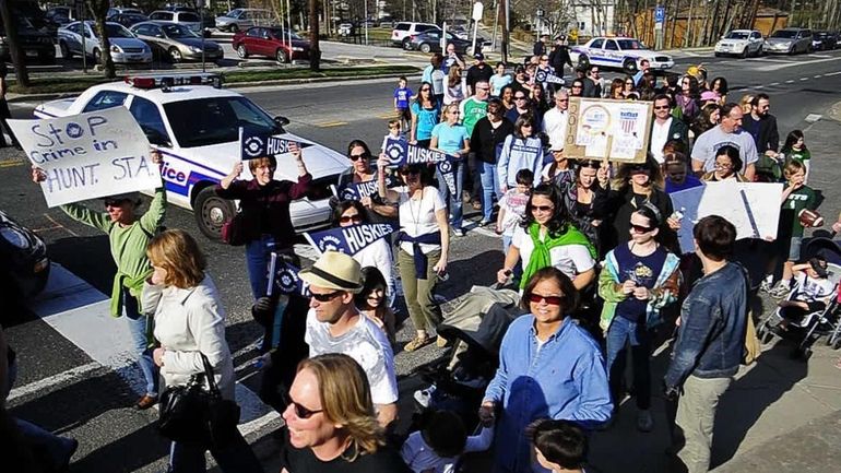 Demonstrators march across Route 25A to rally in front of...