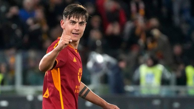 Roma's Paulo Dybala celebrates after scoring his side's third goal...