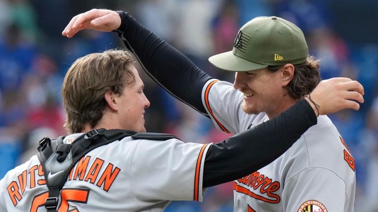 Baltimore Orioles relief pitcher Mike Baumann (53) and catcher Adley...