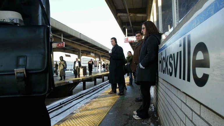 People wait for trains at the Hicksville LIRR train station....