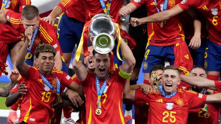 Spain's Alvaro Morata holds the trophy as he celebrates with...