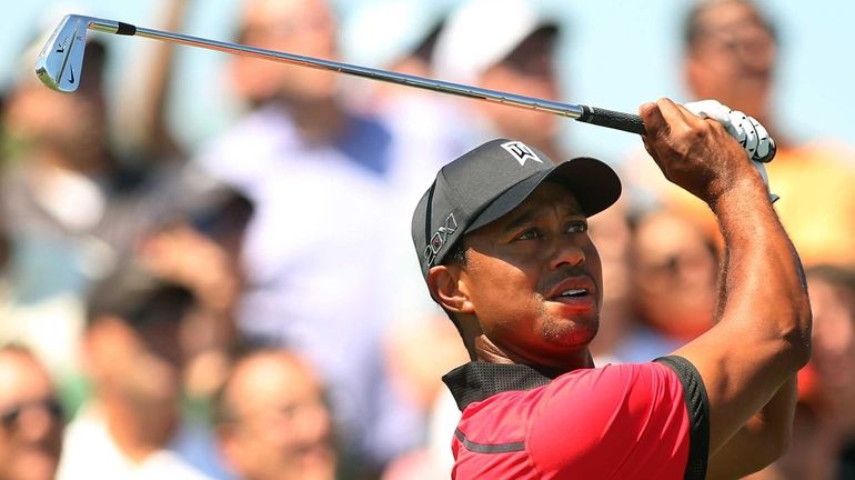 Tiger Woods watches his tee shot on the second tee...