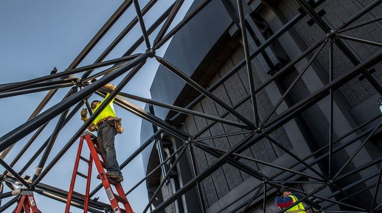 Construction workers at Nassau Coliseum assemble the structures that will...