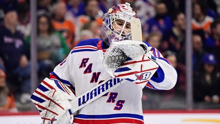 New York Rangers goaltender Igor Shesterkin looks at his stick...