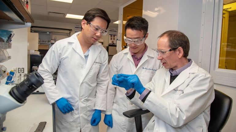 Loren Rieth, right, in his laboratory with research associates Tristan...