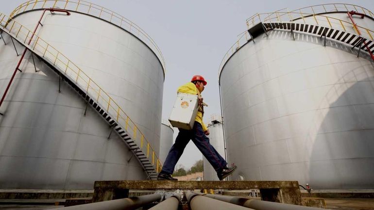 A worker walking past tanks at a PetroChina storage base...