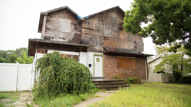 The boarded-up zombie house in North Massapequa on Monday.