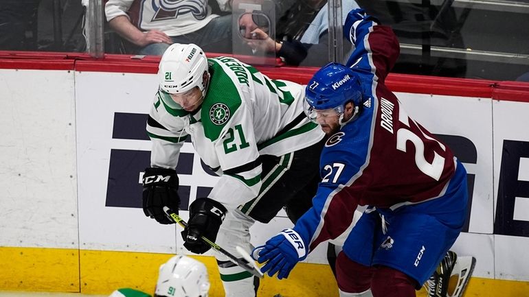 Dallas Stars left wing Jason Robertson, left, flips the puck...