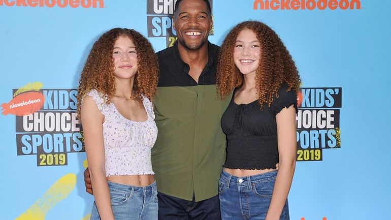 Michael Strahan, center, and his daughters Sophia Strahan, left, and...