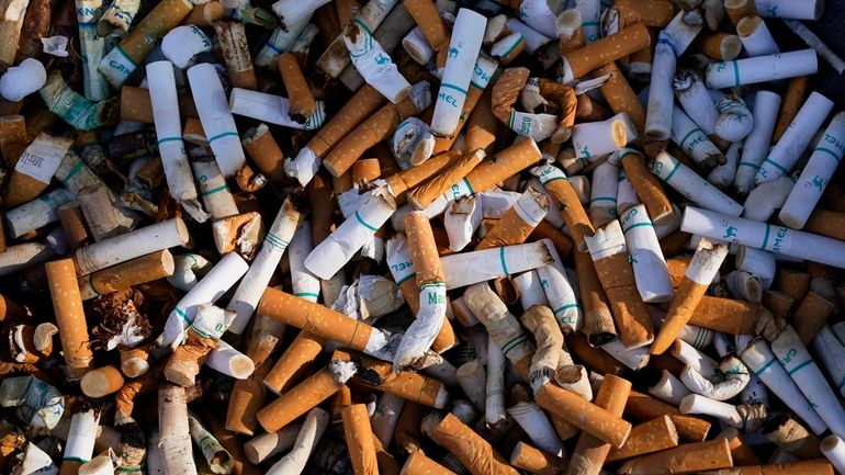 Cigarette butts fill a smoking receptacle outside a federal building...