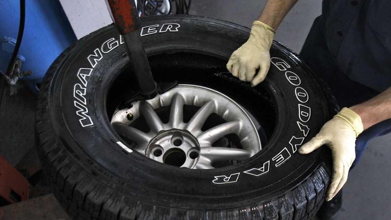 A service technician mounts a Goodyear tire at Long Tire...