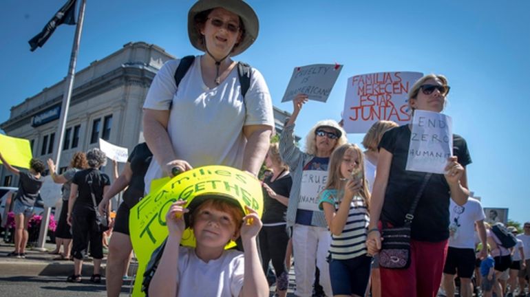 Laura Wenham Kenny, 7, of Bellmore, marches during a rally protesting...