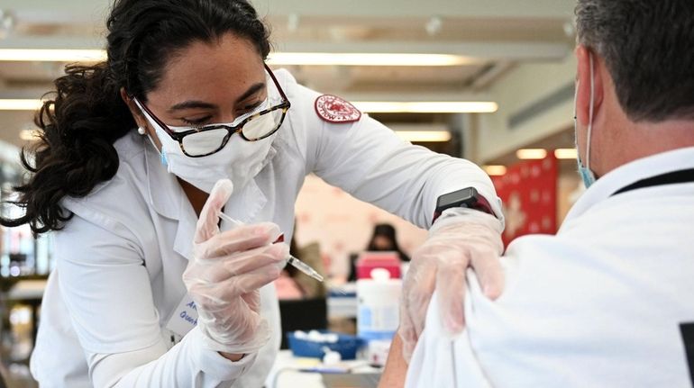 Nursing student Ana Quintanilla delivers the COVID-19 vaccine at a...