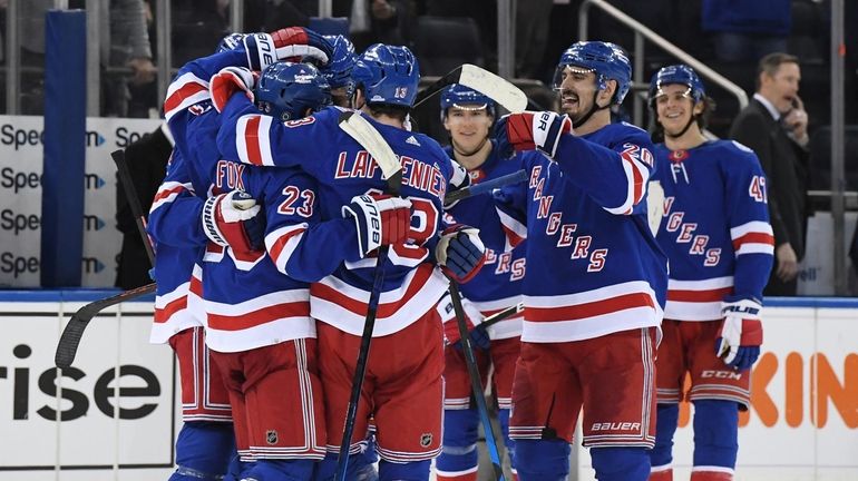 Rangers defenseman Adam Fox (23) is congratulated by teammates after...