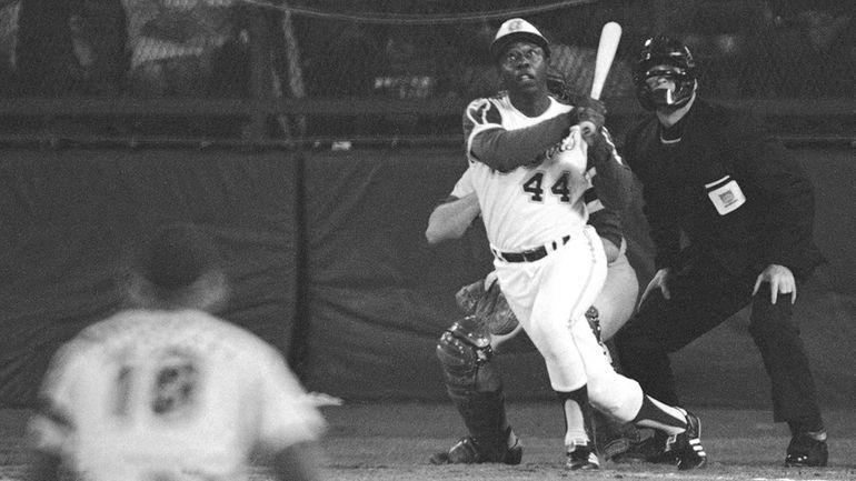 Hank Aaron eyes the flight of his 715th career homer...