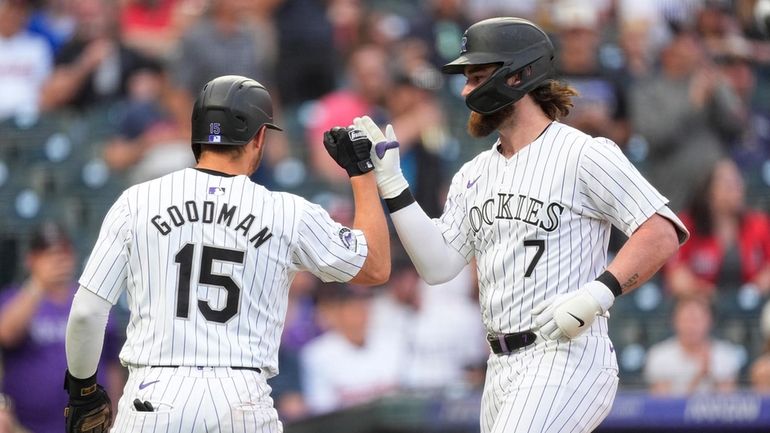 Colorado Rockies' Hunter Goodman, left, congratulates Brendan Rodgers, who hit...