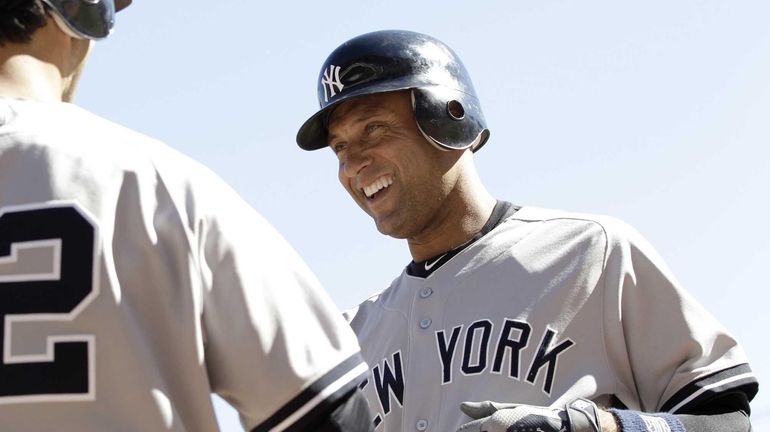 Derek Jeter, right, is congratulated by Eric Chavez after he...