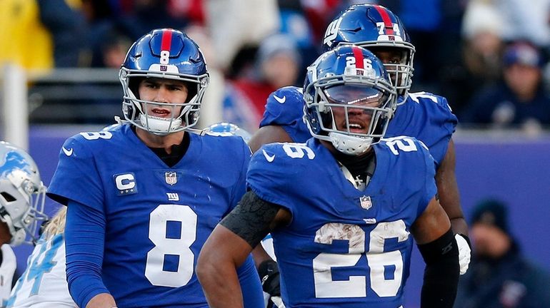 Daniel Jones and Saquon Barkley of the Giants walk to the sidelines after...