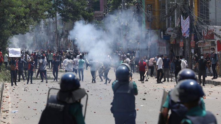 Students clash with riot police during a protest against a...