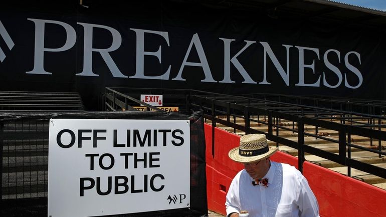 A spectator walks past a closed section of grandstands at...