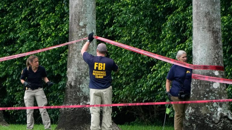 Law enforcement officials work at the scene of the Trump...