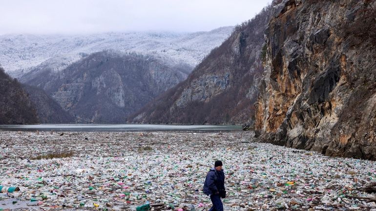 A crane operator walks next to the waste footing in...