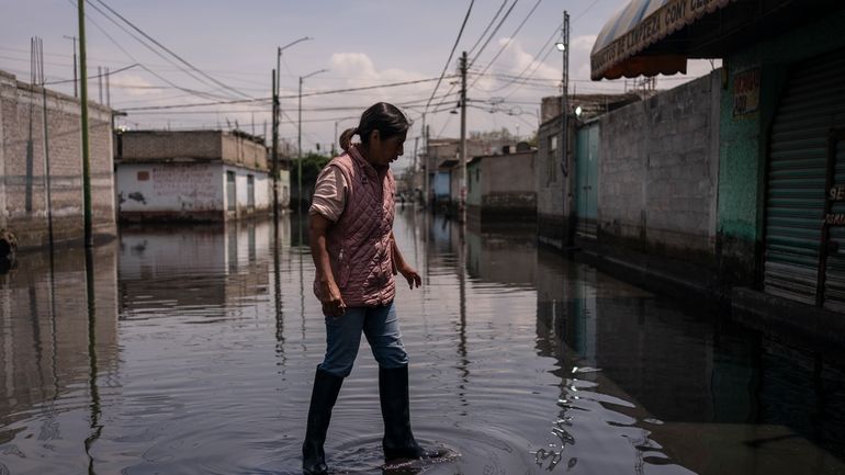 Juana Salazar Segundo walks through sewage-infused floodwaters in Valle de...