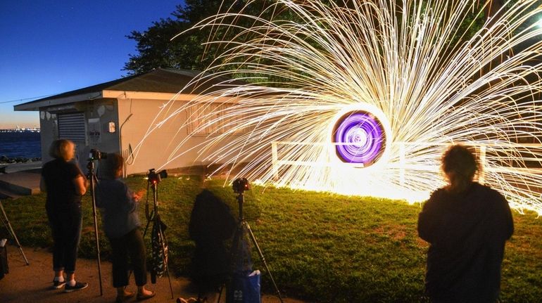 Eddie Giron, 40, of Levittown, creates a sparkling light-painting display...