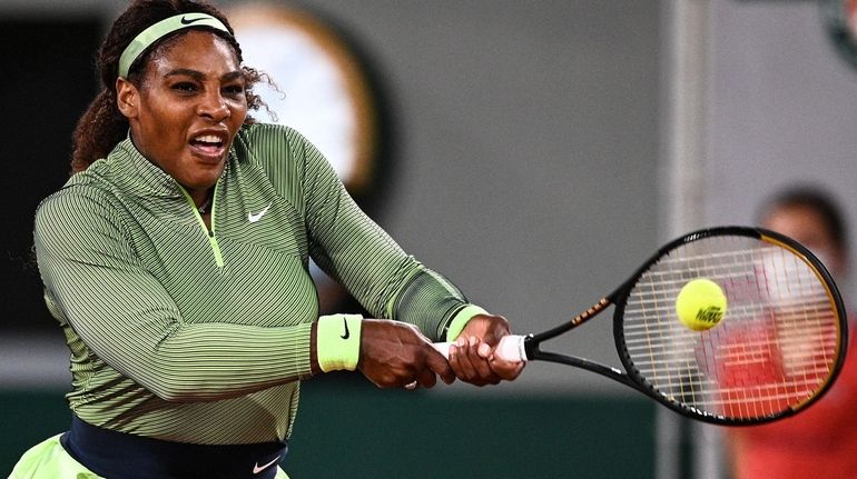 Serena Williams returns the ball to Romania's Irina Begu during their...