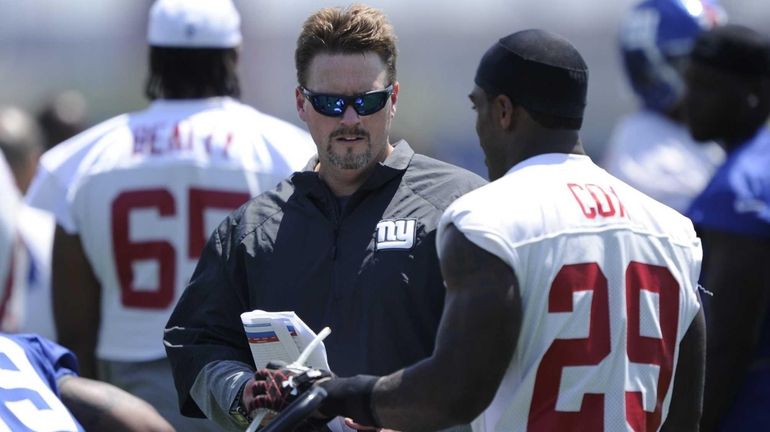 Giants offensive coordinator Ben McAdoo talks to running back Michael...