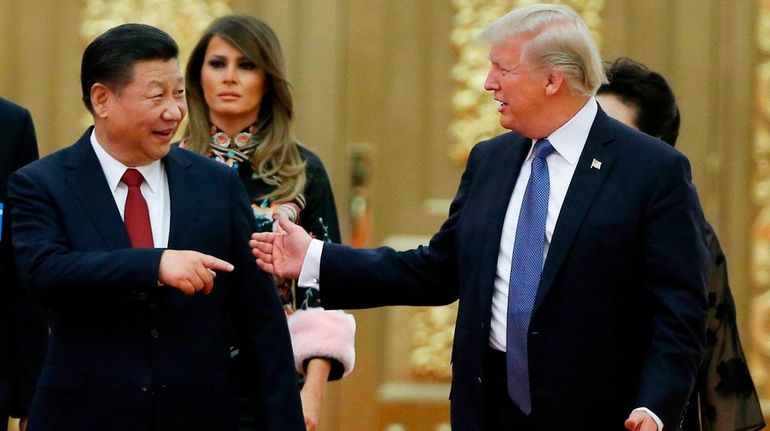 China's President Xi Jinping talks with President Donald Trump before...