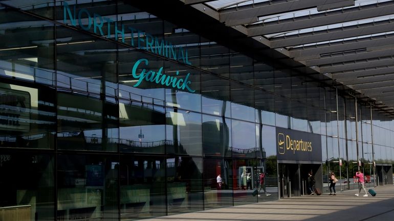 Passengers walk into the Departures entrance at the North Terminal...