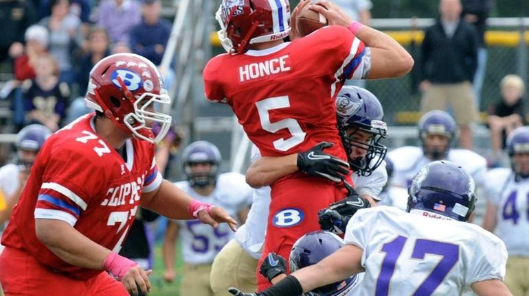 Bellport's Justin Honce is tackled by Islip defenders. (Oct. 1,...