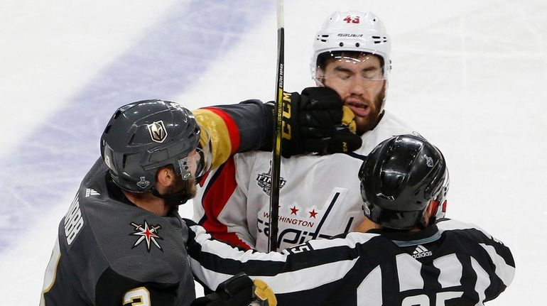 Vegas Golden Knights defenseman Brayden McNabb, left, hits Washington Capitals...