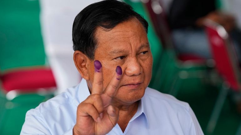 Indonesian presidential candidate Prabowo Subianto displays a victory symbol after...