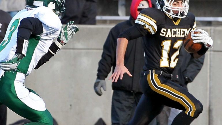 Sachem North quarterback Mike Licata (no.12) heads up the sideline...