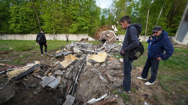 People look at fragments of the television tower which was...