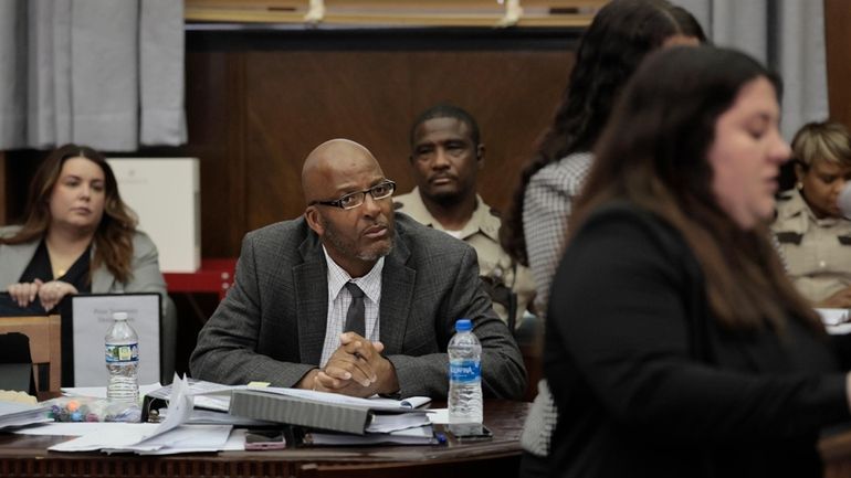 Christopher Dunn, center, listens to Rachael Moore, special assistant with...