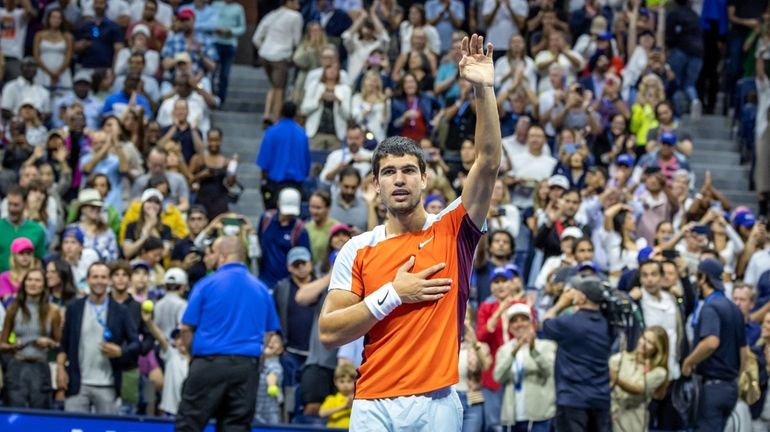 Carlos Alcaraz waves to the crowd after defeating Casper Ruud...