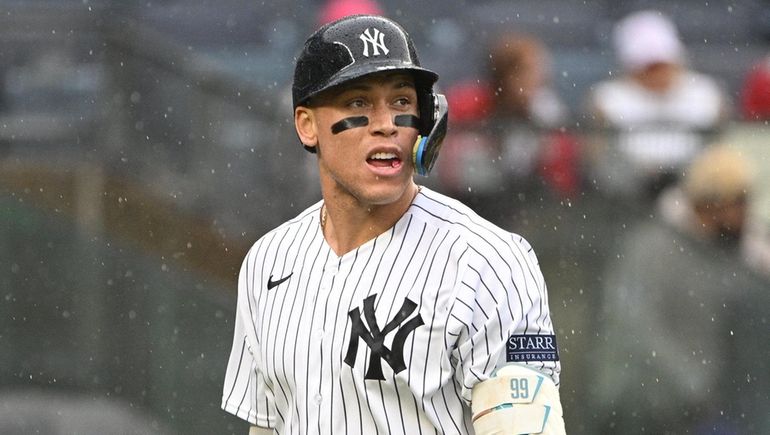 Yankees designated hitter Aaron Judge returns to the dugout after...