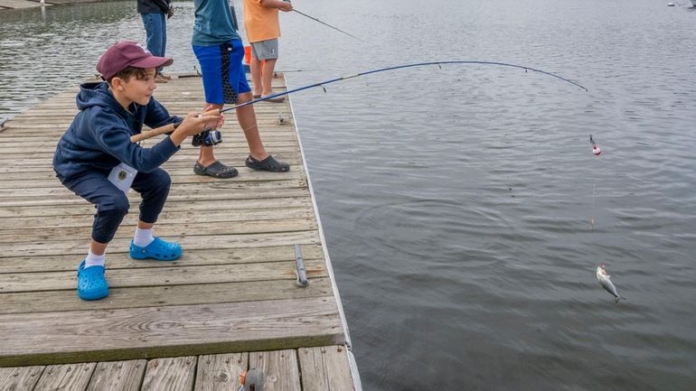 Julien Netter, 9, of Huntington, catches a snapper at the 20th...