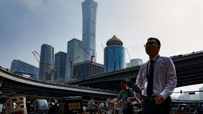 Pedestrians cross an intersection with the background of the central...