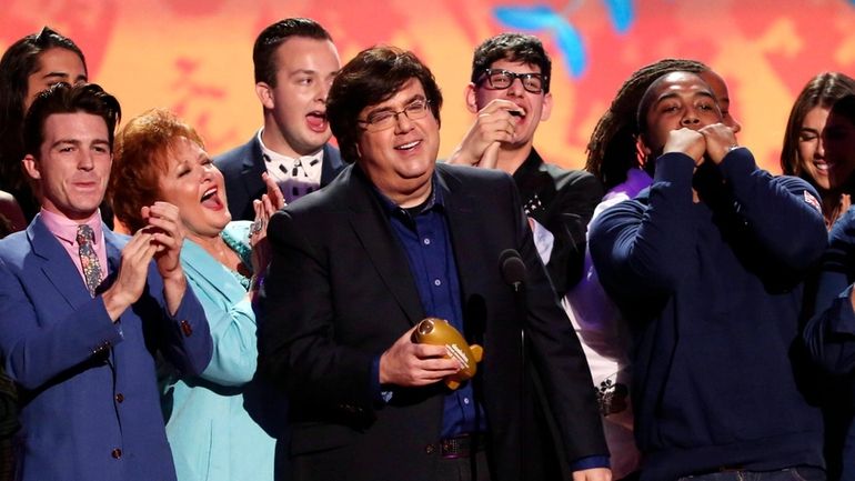 Dan Schneider, center, accepts an award in Los Angeles. Schneider...