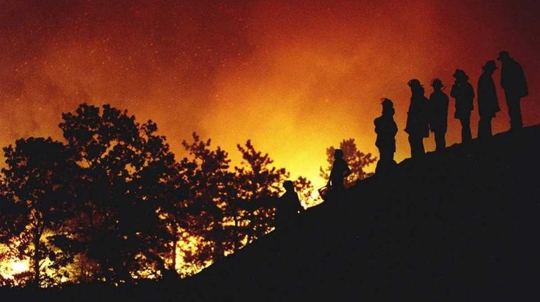 Firefighters survey the Sunrise Fire on Aug. 25, 1995 on Old Country...