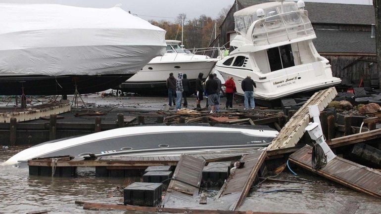 Boat owners survey the damage caused by Hurricane Sandy, including...