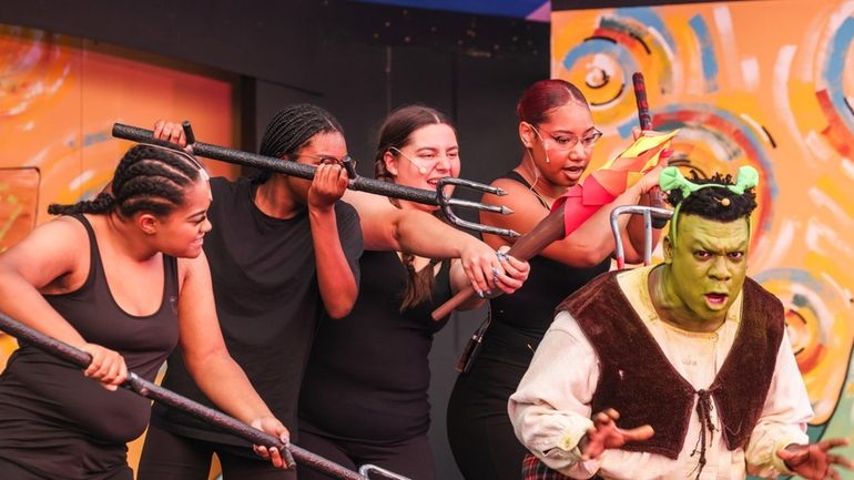 Performers use pitchfork props during the Malverne High School summer...