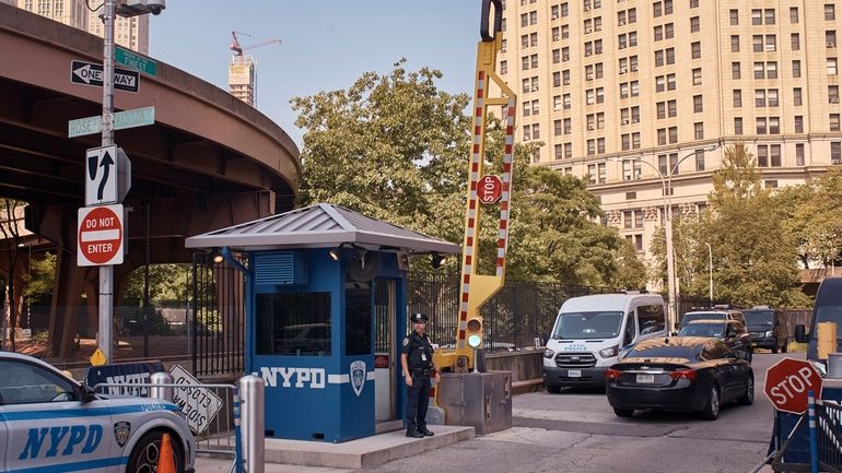 A police officer stands guard outside One Police Plaza NYPD...