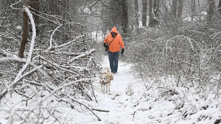 Kenny Martin, of Rocky Point, and his dog Eddie walk...