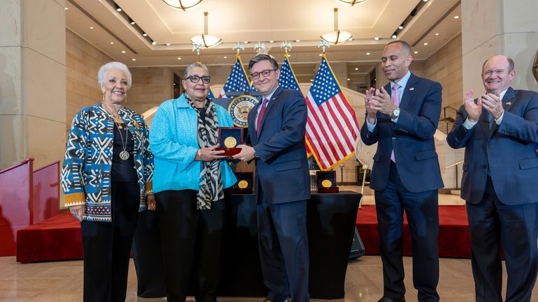 House Speaker Mike Johnson, R-La., center, presents a Congressional Gold...